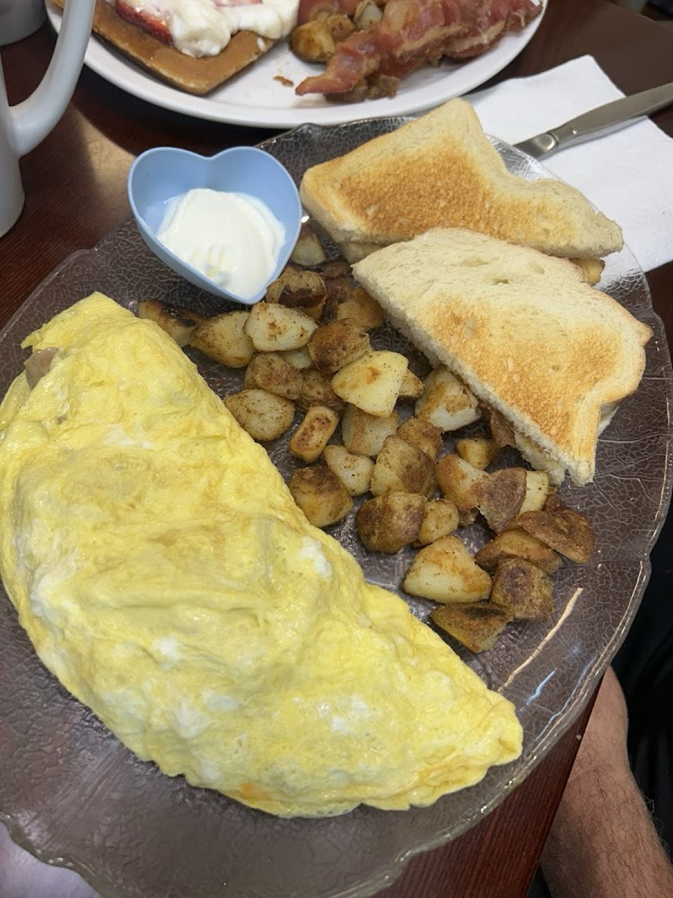 Folded omelette with panfries, buttered toast and a side of sour cream